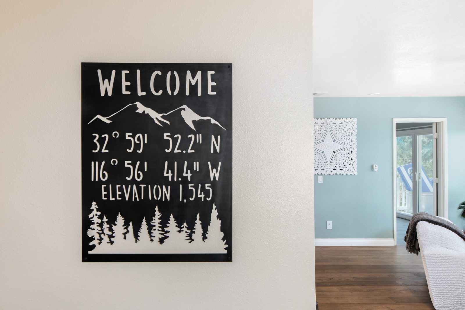 A steel welcome sign in the entry showing the property's coordinates and an elevation of 1,545 feet.