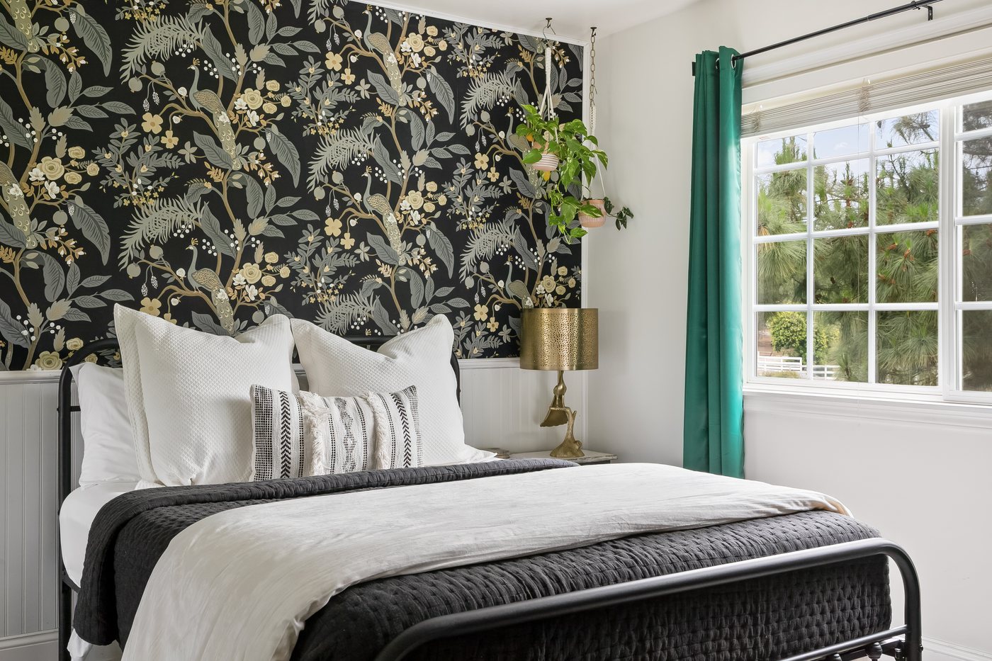 The queen bed in the Floral Peacock, close up against the botanical wallpaper.