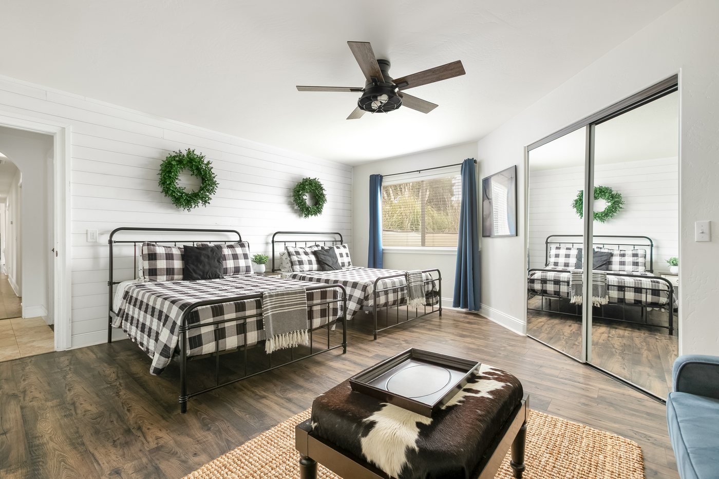 The Adventure Room: two full beds in buffalo check against a shiplap wall.
