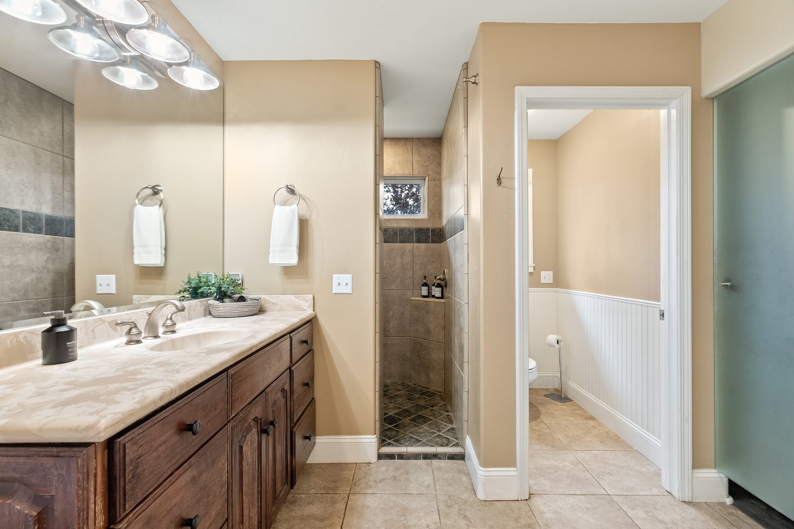 The Primary bathroom with two sinks and a tiled walk-in shower.