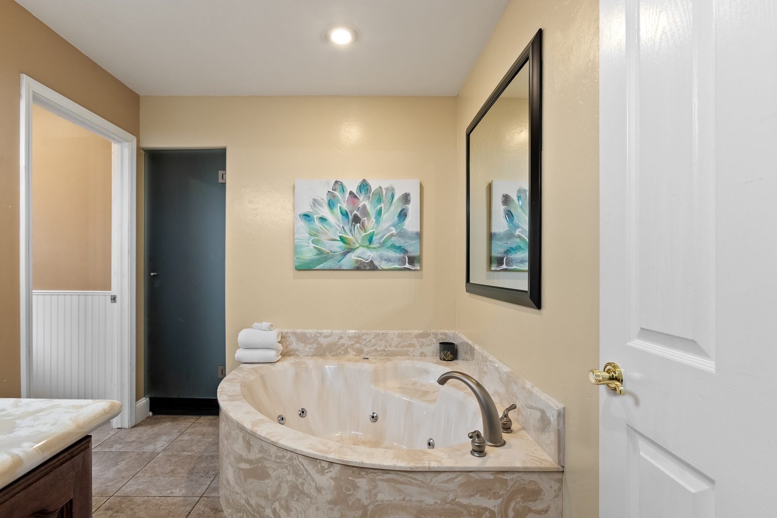 The corner soaking tub in the Primary bathroom, with towels folded on the ledge.