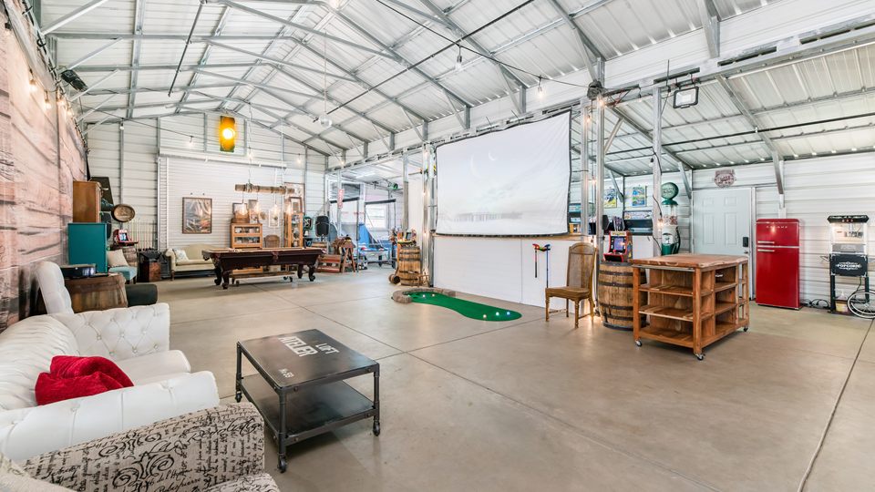 The barn from the lounge end, looking down the hall to the projection screen and the putting green.