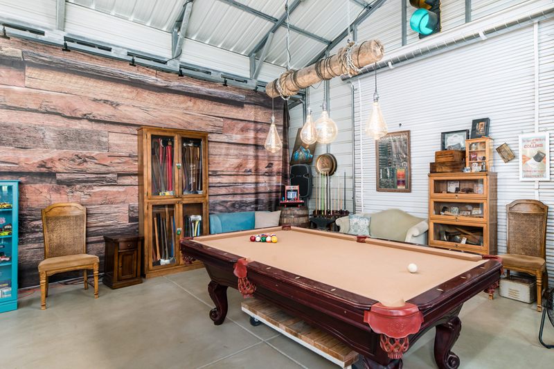 The 8-foot billiards table under the beam Edison light, in front of the reclaimed wood wall.