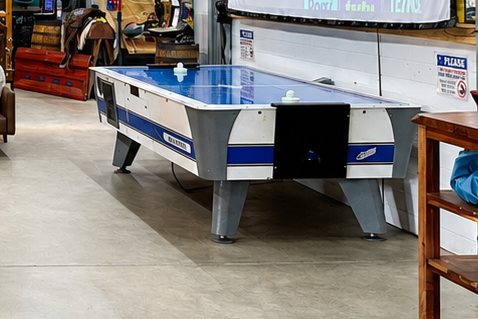 The full-size air hockey table in the barn, below the projection screen.